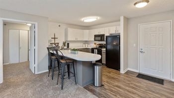 A kitchen with a white countertop and black appliances.