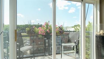 A patio with a table and chairs overlooking a garden.