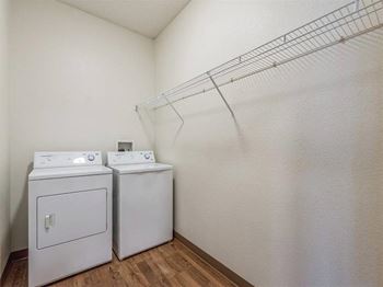 Two white washing machines in a laundry room.