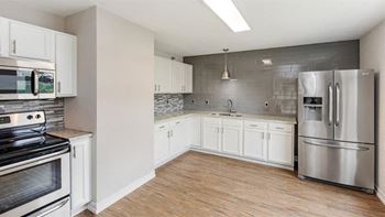 A kitchen with white cabinets and stainless steel appliances.