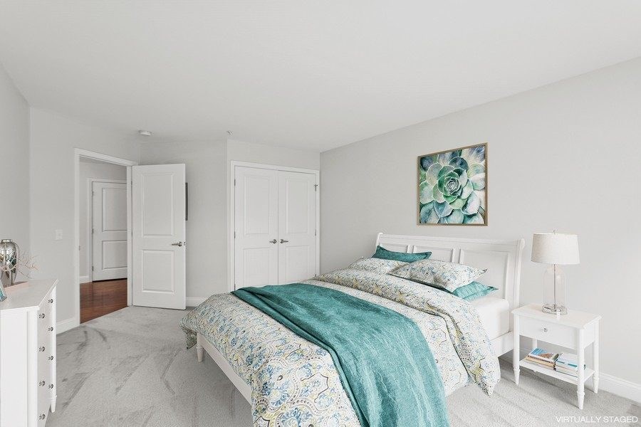 A bedroom with a bed, nightstand, and two doors.