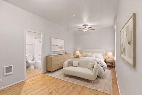 A bedroom with a bed, nightstand, and a couch.