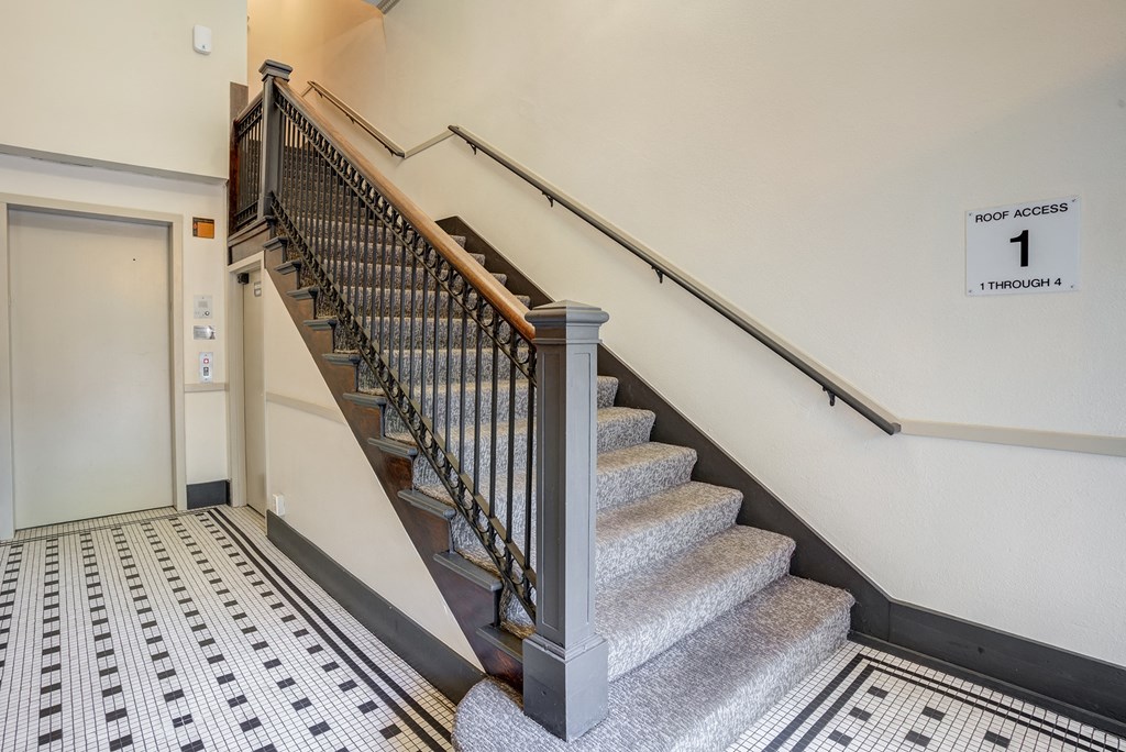 a staircase with a railing and an elevator at the bottom of the stairs