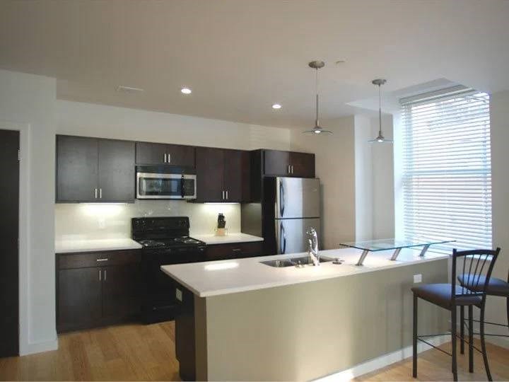 A kitchen with a black stove top oven and a black refrigerator.