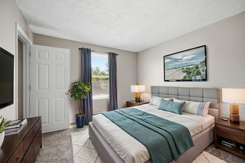 A bedroom with a large bed and a painting on the wall.