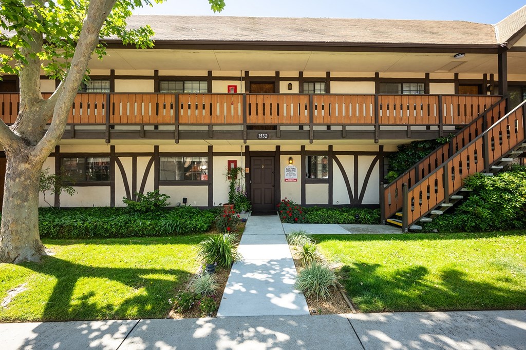 the front of a building with a sidewalk and grass at Oak Park Apartments, Solvang, CA 