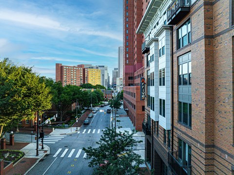 A city street with buildings on both sides and a crosswalk in the middle.