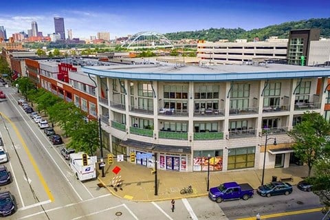 a large building with a blue roof on a city street at Flats at Southside, Pittsburgh Pennsylvania