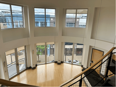 the view from the top of the stairs in a building with large windows