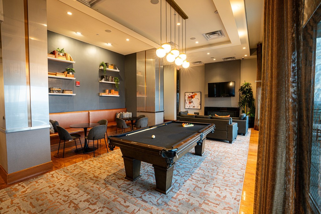 A room with a pool table and a TV.