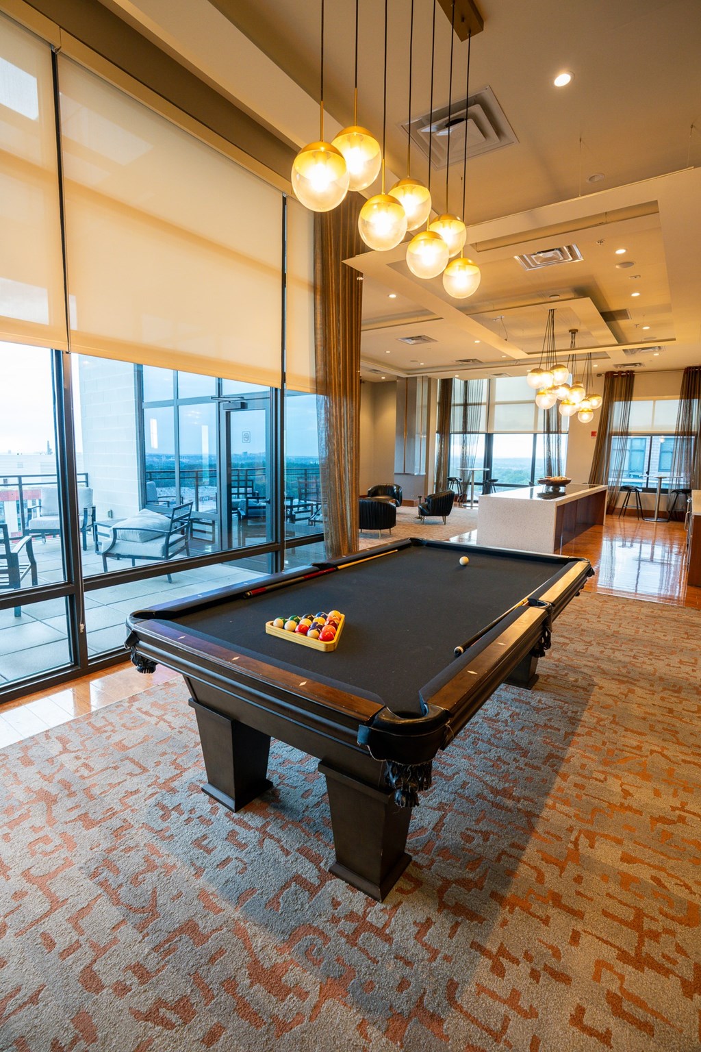 A pool table in a room with a view of the outside.