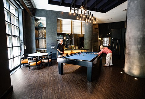 A woman is playing pool in a room with a pool table.