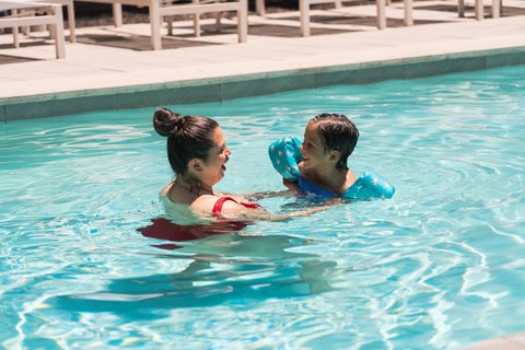A woman and a child are swimming in a pool.