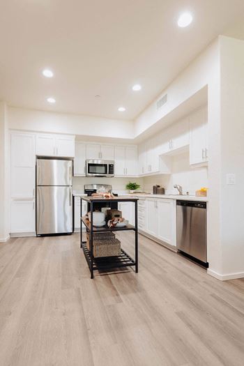 a kitchen with white cabinets and stainless steel appliances