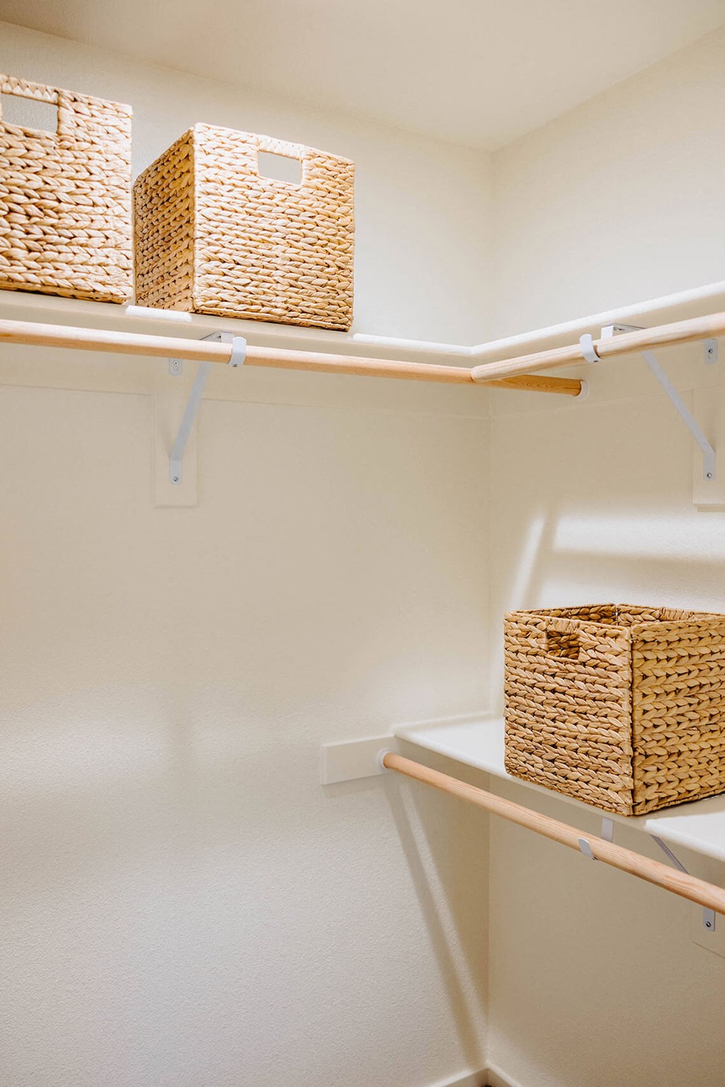 a walk in closet with wicker baskets and white shelves at Arrive Paso Robles, Paso Robles