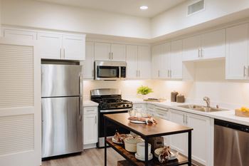 a kitchen with white cabinets and stainless steel appliances
