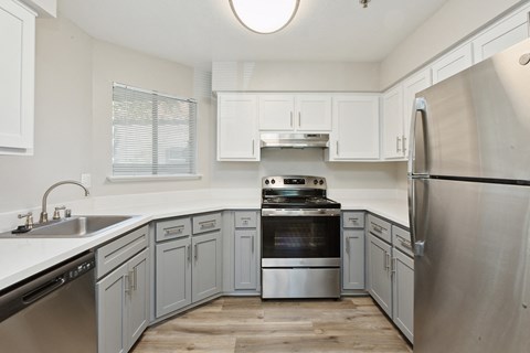 a kitchen with white cabinets and stainless steel appliances