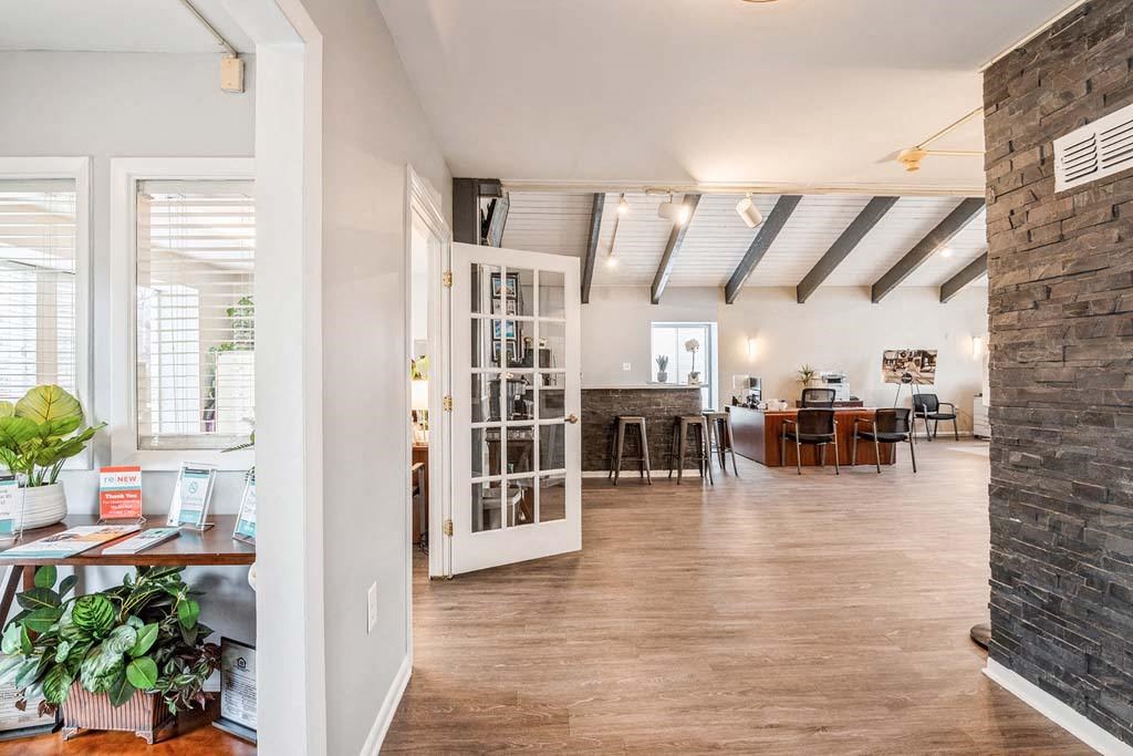 a living room with a fireplace and a ceiling with exposed beams at ReNew Odenton, Odenton, Maryland