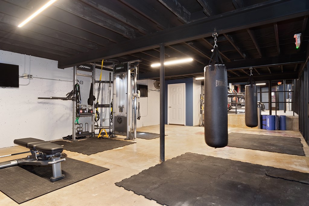 A gym with a punching bag hanging from the ceiling.