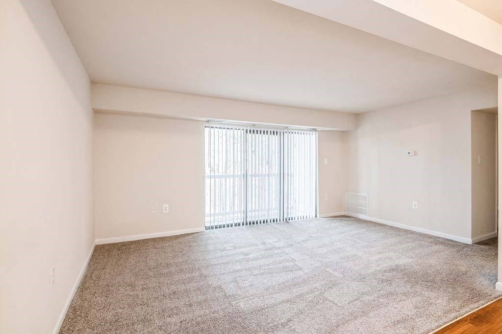 a bedroom with a large window and a carpeted floor at ReNew Odenton, Odenton