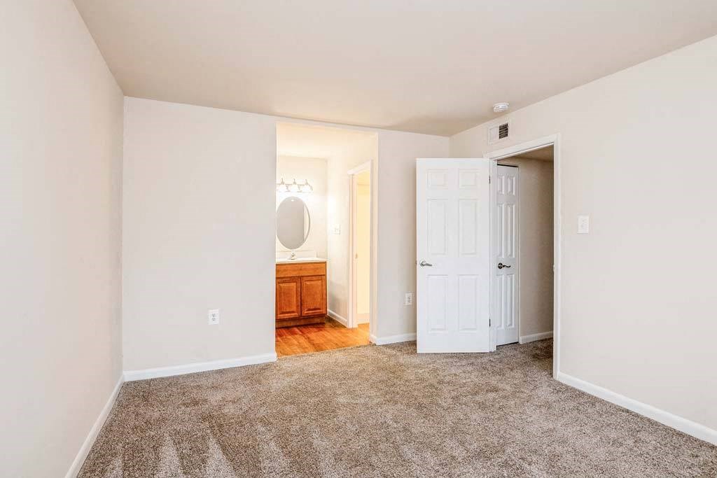 a bedroom with a bed and a doorway to a bathroom at ReNew Odenton, Maryland