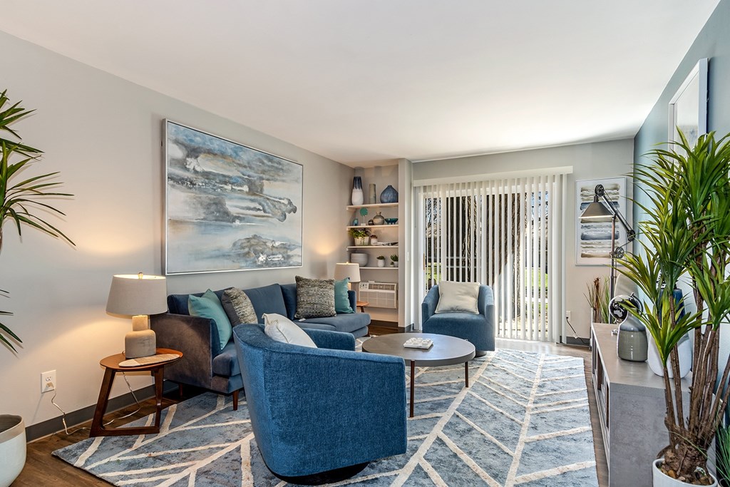 A blue couch is in the middle of a living room.