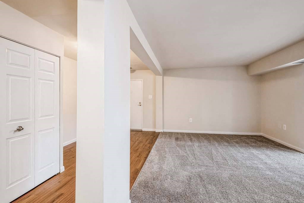 a bedroom with a door and a carpeted floor at ReNew Odenton, Maryland, 21113