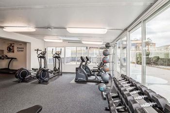 a gym with a lot of exercise equipment and windows