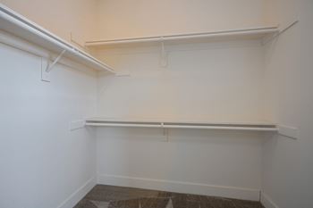 a empty room with a white wall and a shelf on the wall