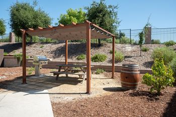 a picnic table in a park with a wooden canopy