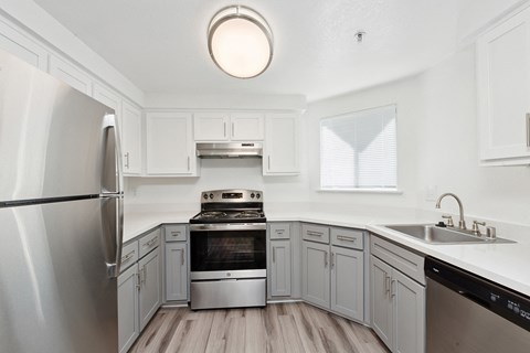 a renovated kitchen with white cabinets and stainless steel appliances