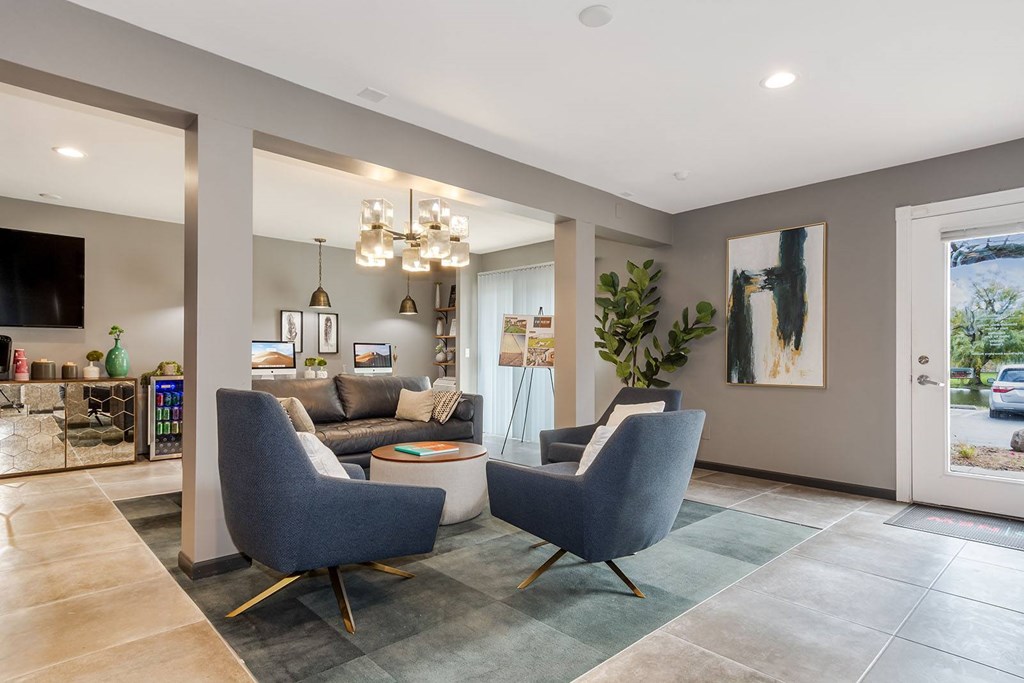 A modern living room with grey chairs and a grey sofa.
