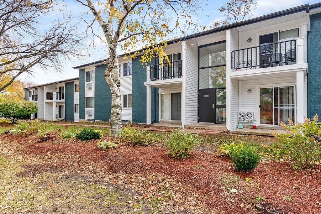 A row of modern townhouses with white and green exteriors.