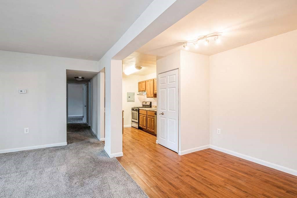 a living room with a wooden floor and a kitchen in the background at ReNew Odenton, Maryland
