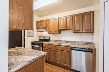 a kitchen with wooden cabinets and a stove top oven