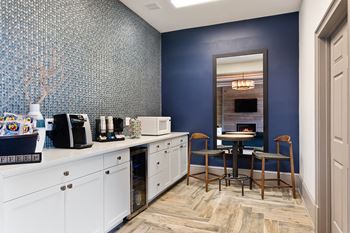 a kitchen with a coffee bar and a dining room with a table and chairs