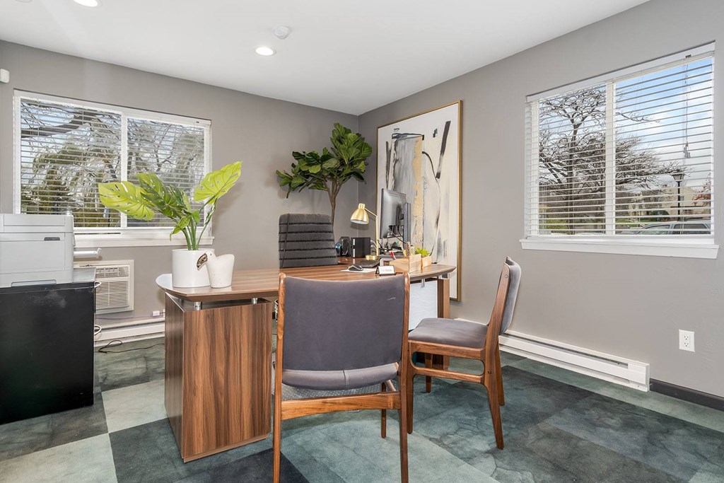 A room with a chair, a table, and a plant.