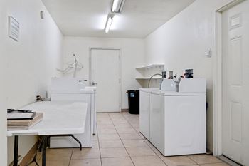 a laundry room with two washing machines and a table