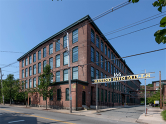 an old brick building with a sign on the corner of a street