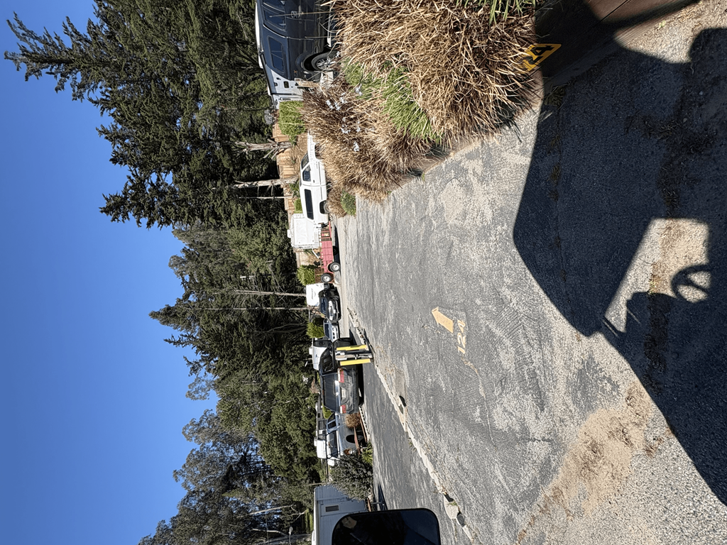 A white car is parked on the side of a road.