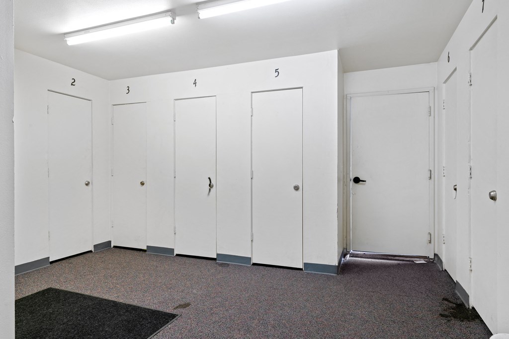 a row of white lockers in a room with a carpeted floor at ReNew Eagle River, Eagle River, AK