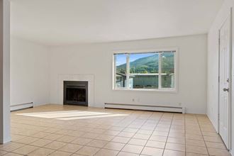 a living room with a fireplace and a large window