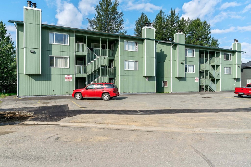 a green apartment building with a red car parked in front of it at ReNew Eagle River, Alaska