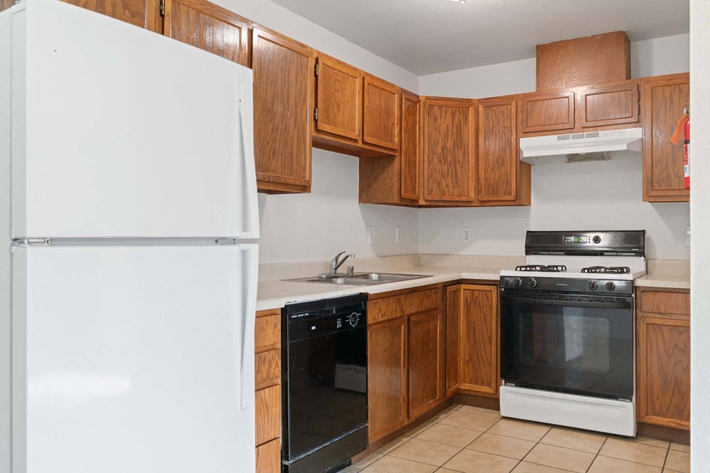 a kitchen with wooden cabinets and white appliances at ReNew Eagle River, Alaska, 99577
