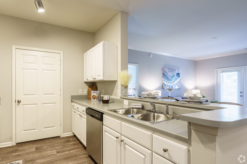 a kitchen with white cabinets and a stainless steel sink