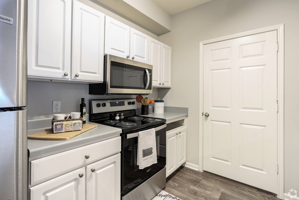 a kitchen with stainless steel appliances and white cabinets