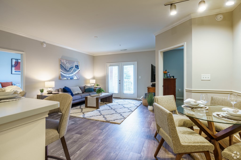 a living room and dining room with a table and chairs