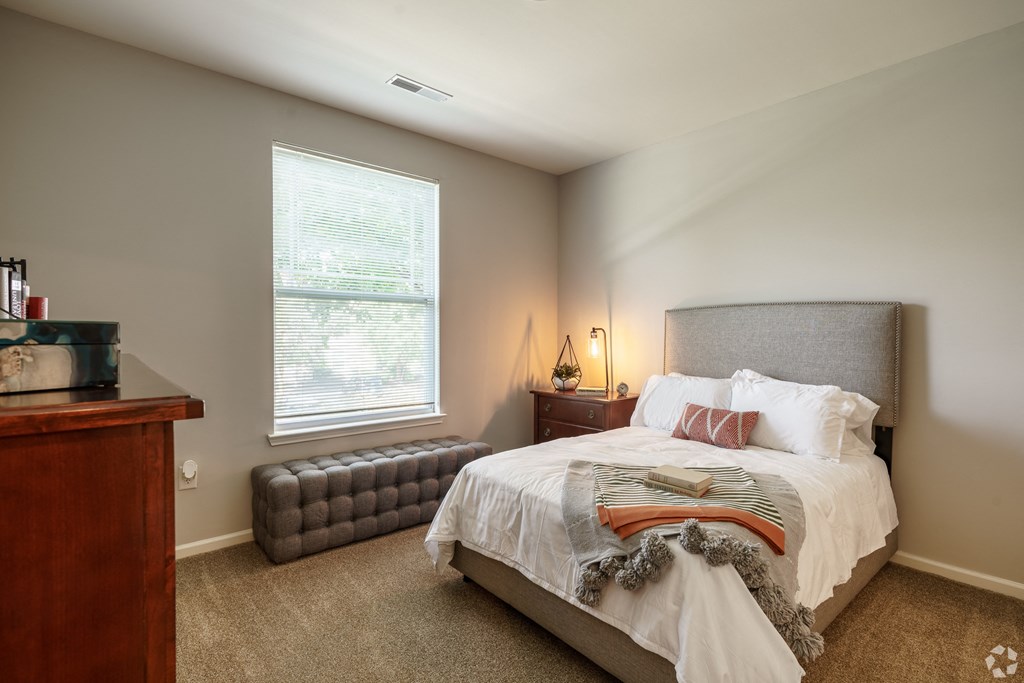 a bedroom with a bed and a dresser and a window
