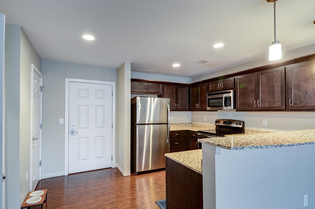 A kitchen with a stainless steel refrigerator and microwave.