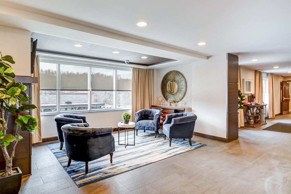 A living room with a large window and a view of a parking lot.